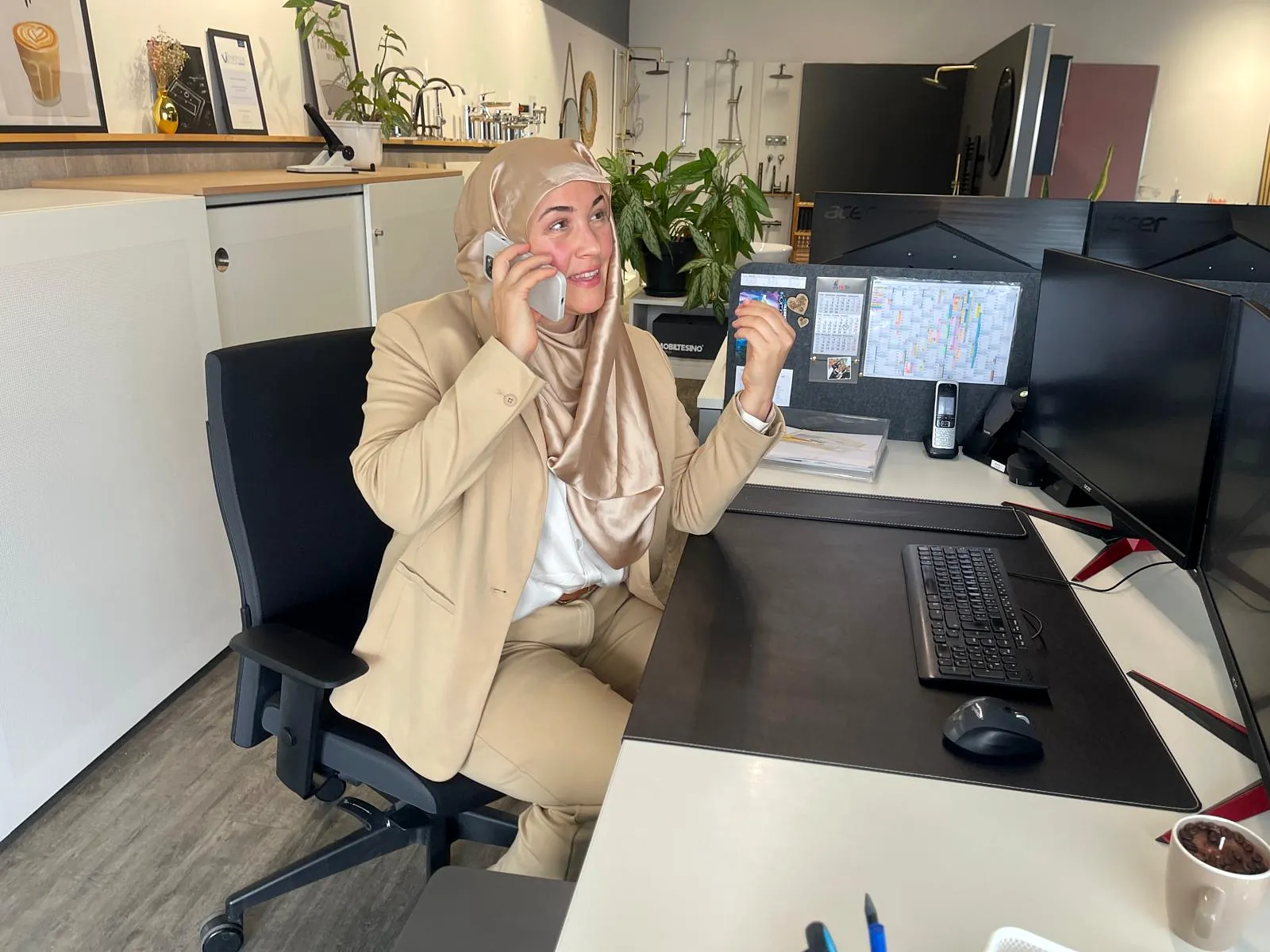 Julia Vural lächelt bei einem Telefonat an ihrem Arbeitsplatz